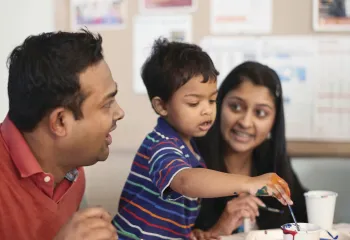 Mom and dad with son painting