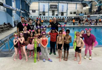 Swim Team posing with coaches at Swim Meet