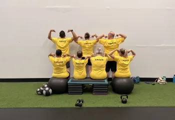 LiveStrong participants pointing to the word "survivor" on the back of their shirts.