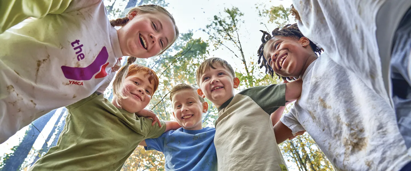 Kids laughing in a huddle outside