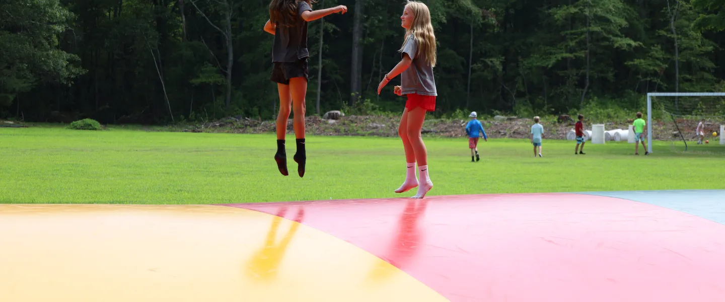 Two girls jumping on a Kangaroo Jumper