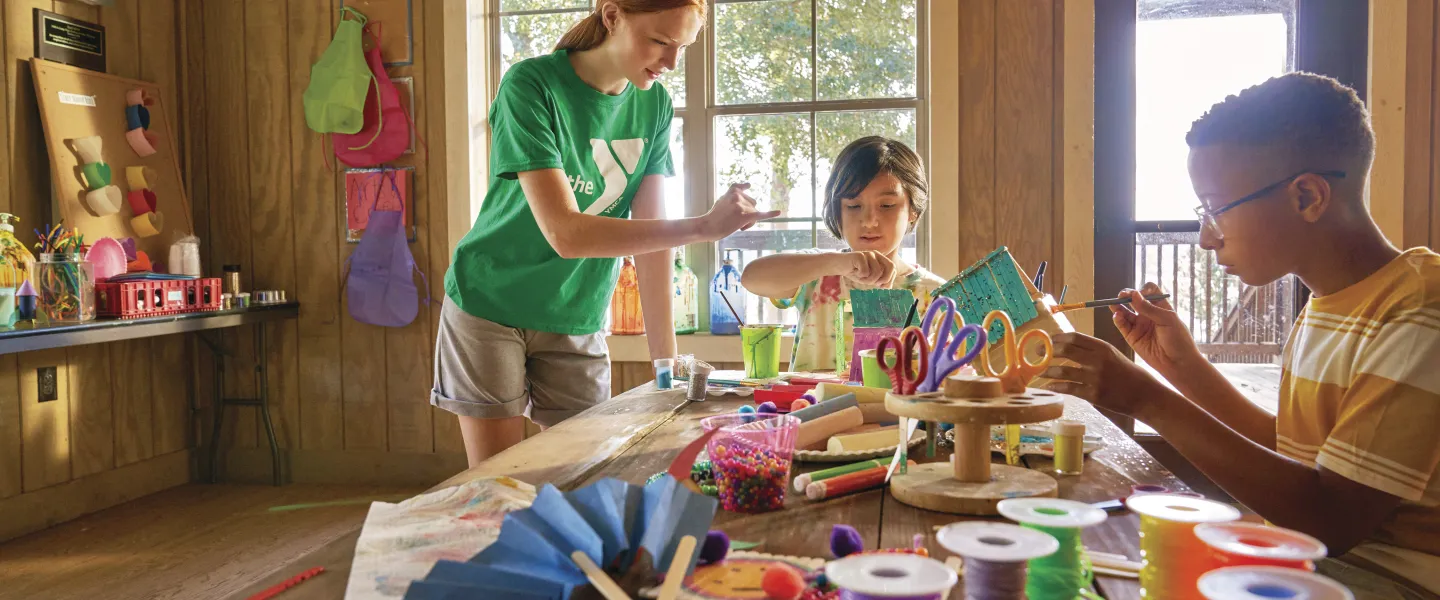 Two kids taking an art class with an instructor.