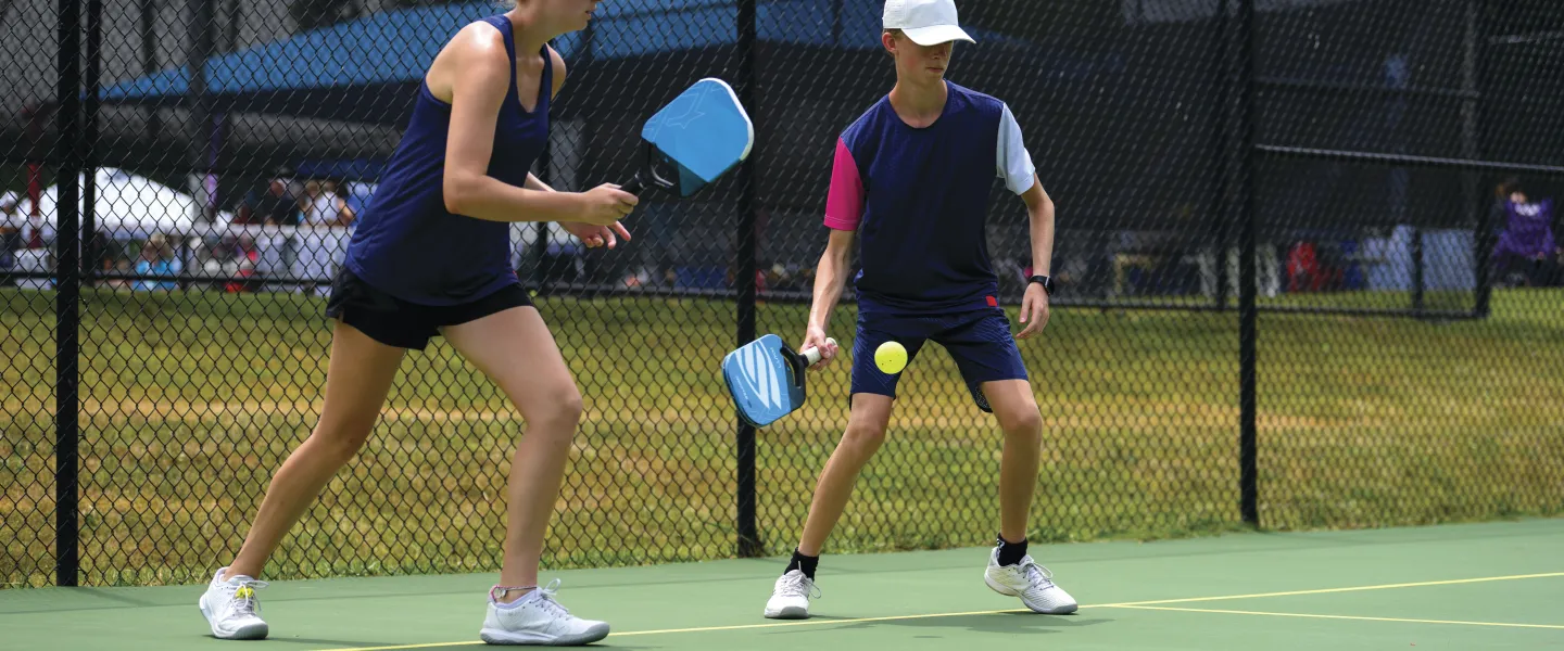 Woman and boy playing pickleball