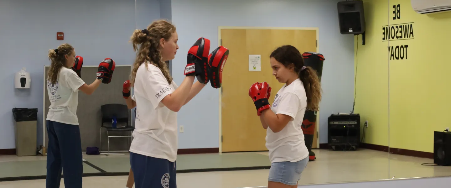 Female student working with female instructor on punches.