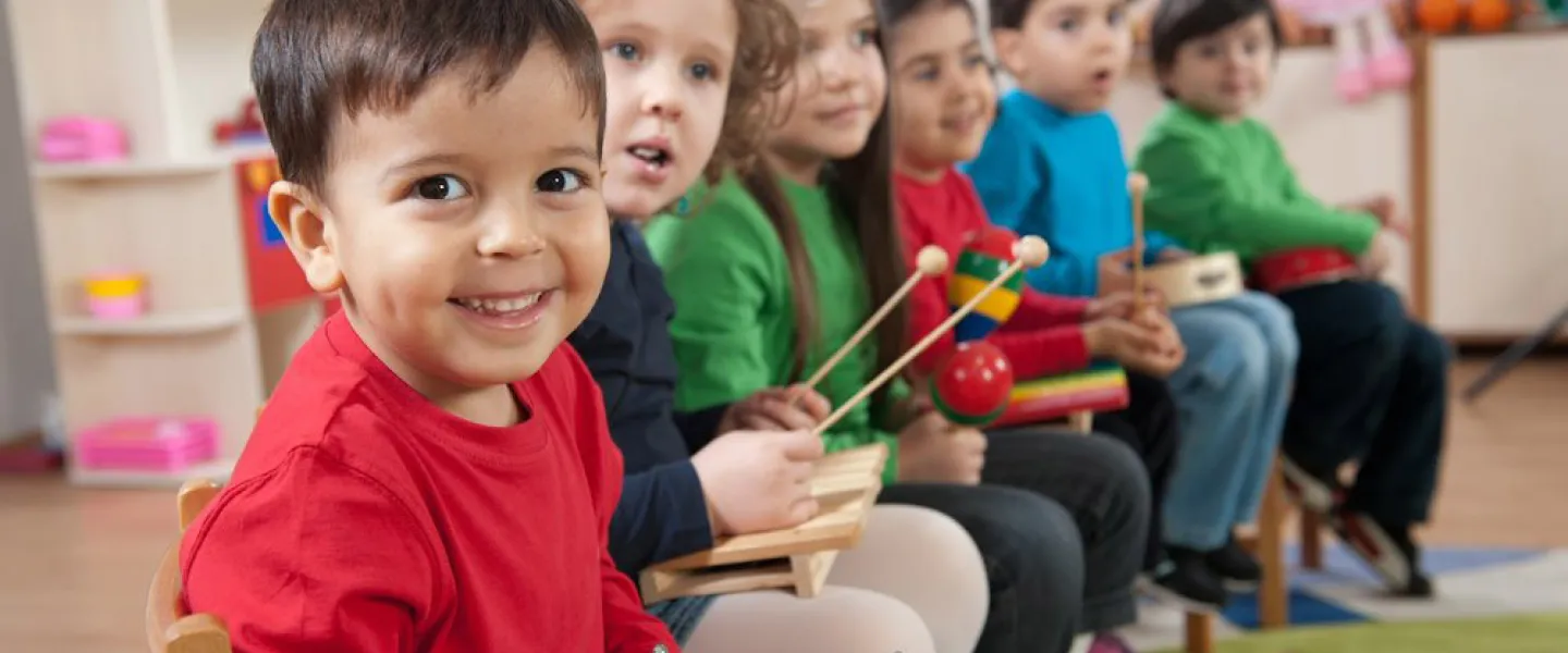 Young kids playing a variety of different musical instruments