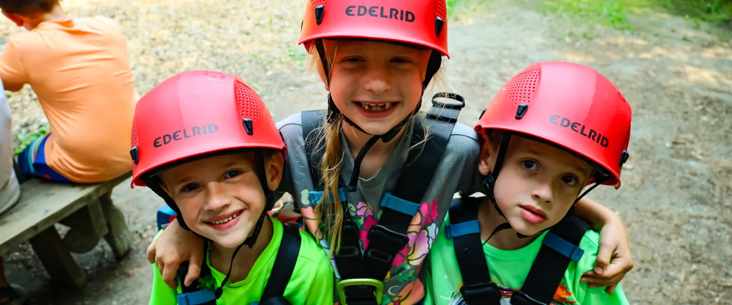 Three Kids SMiling at Summer Camp in Rock Climbing Gear