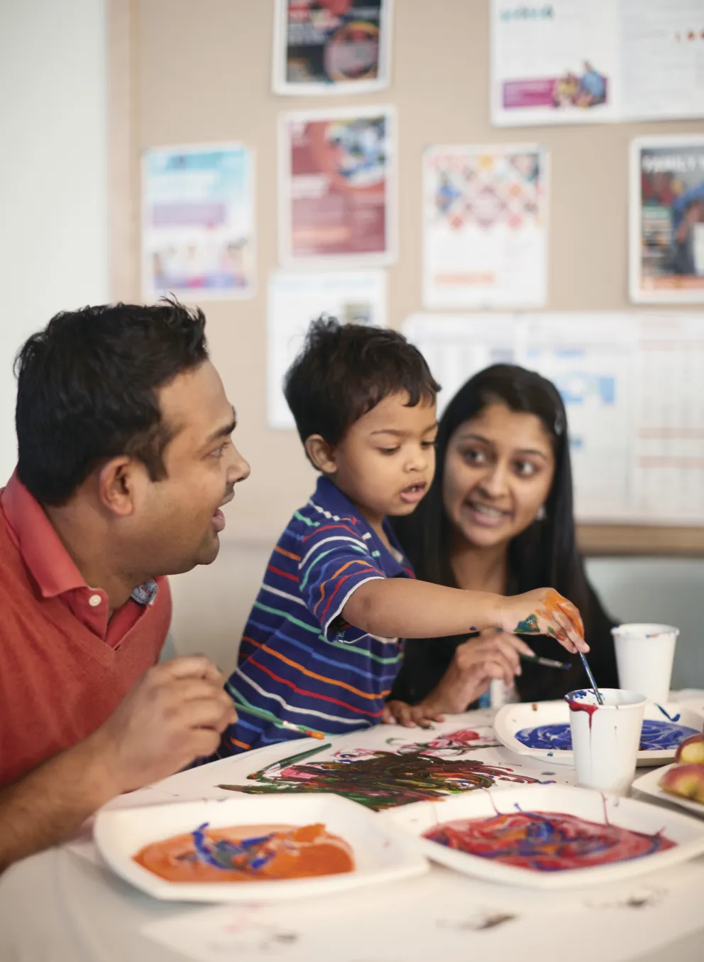 Mom and dad with son painting