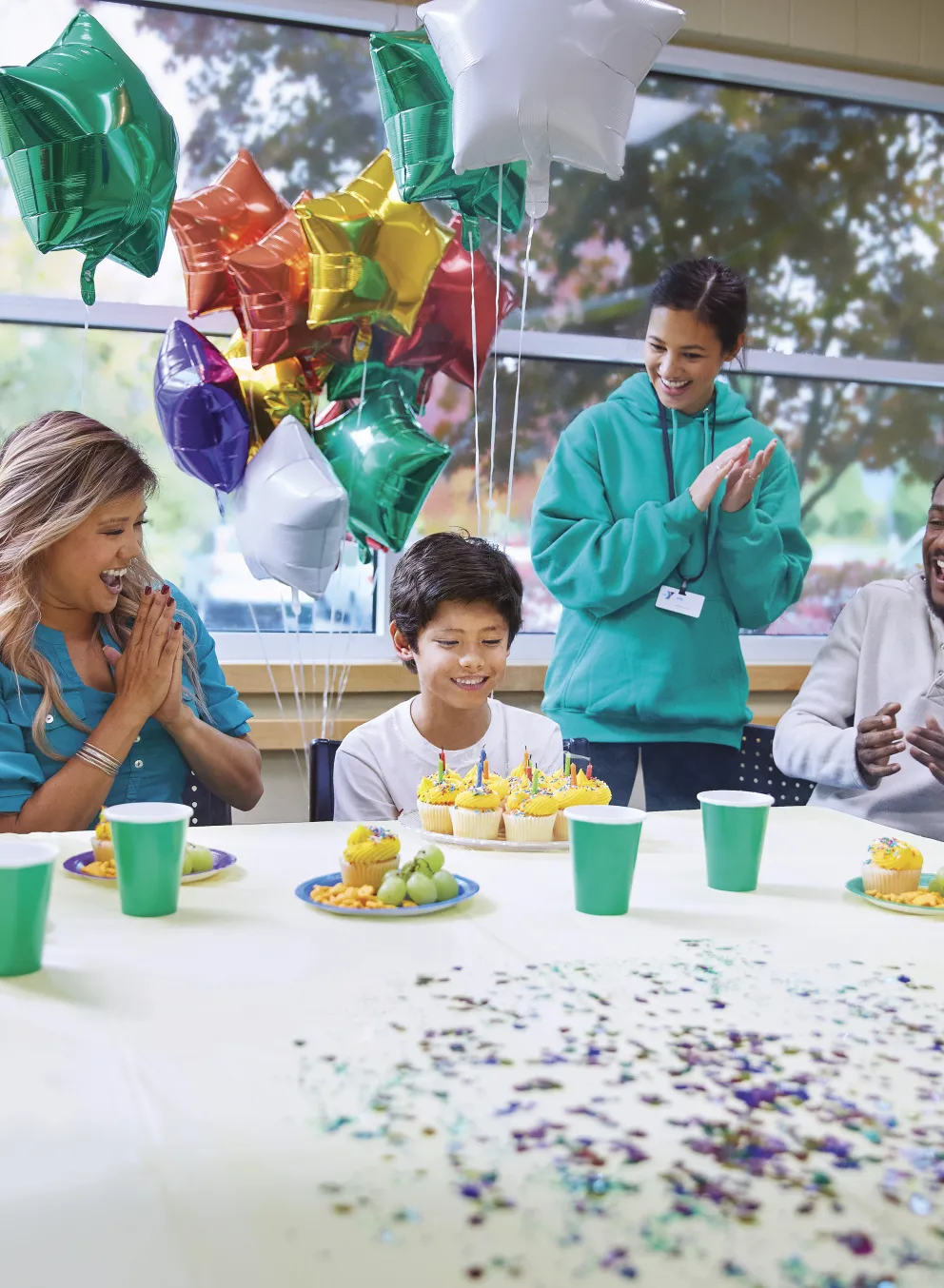 Kids sitting around a table celebrating a birthday