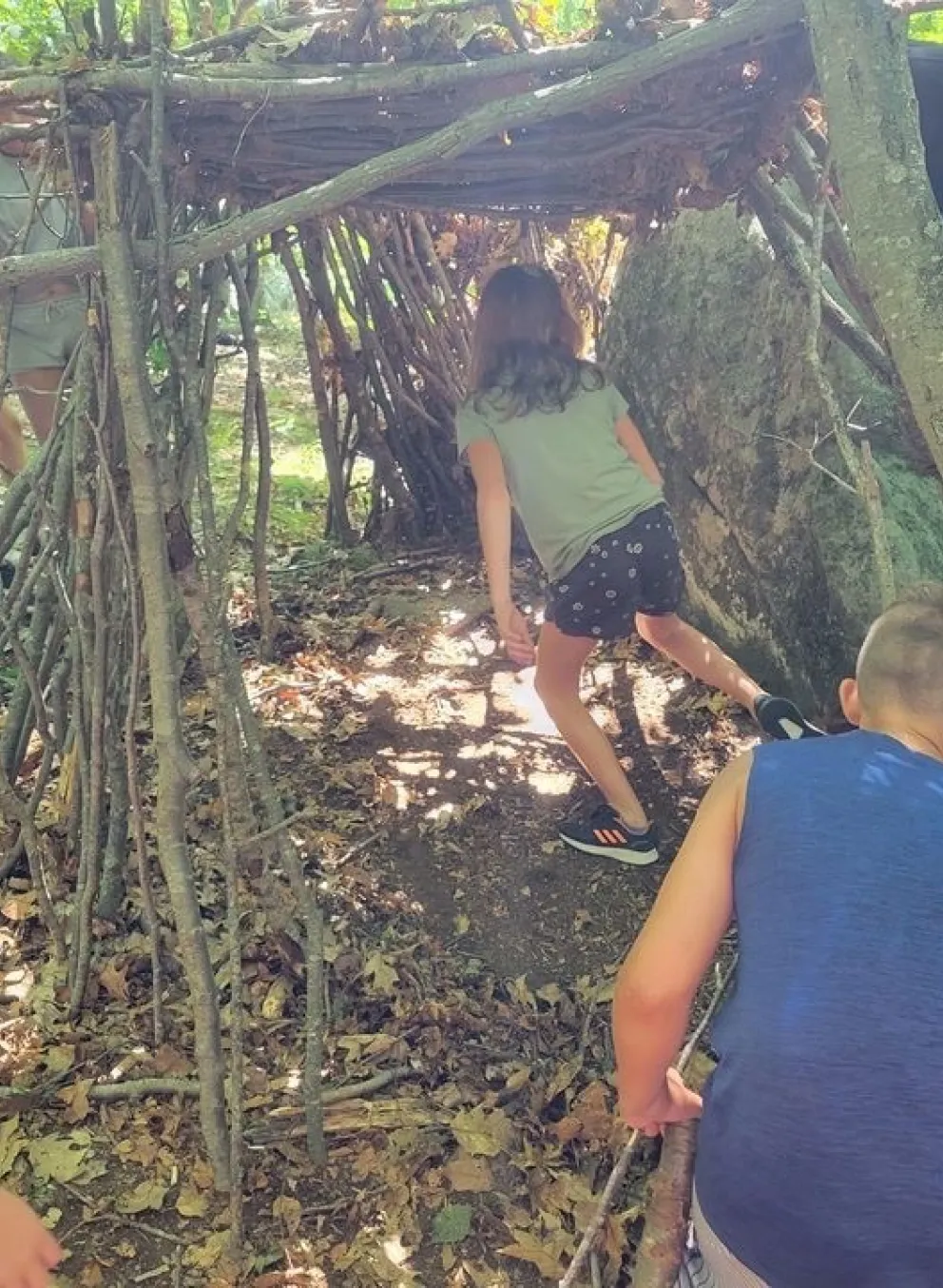 Kids building a fort out of nature