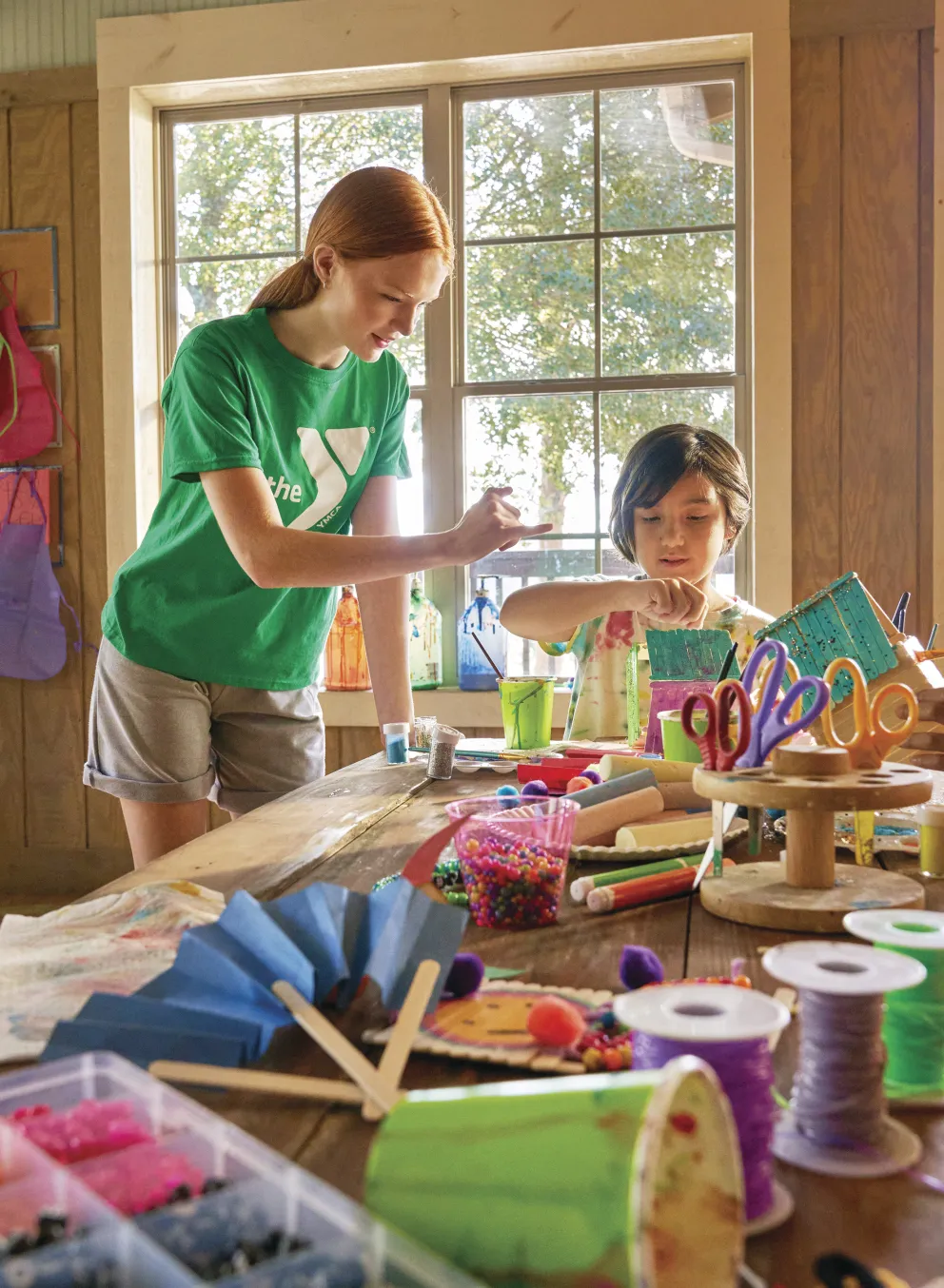 Two kids taking an art class with an instructor.