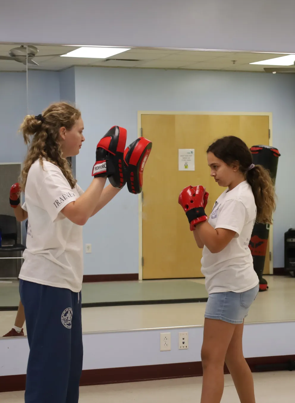 Female student working with female instructor on punches.
