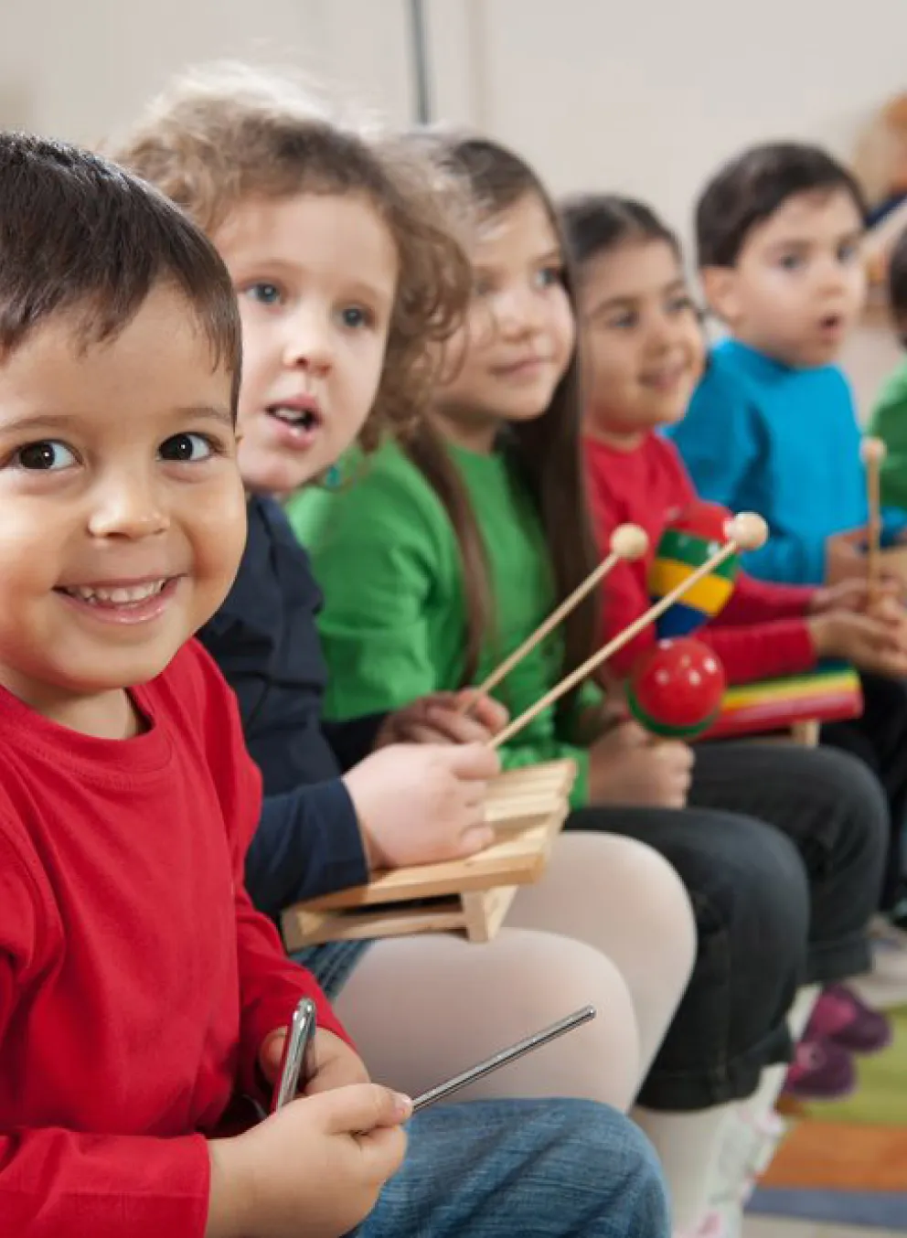 Young kids playing a variety of different musical instruments
