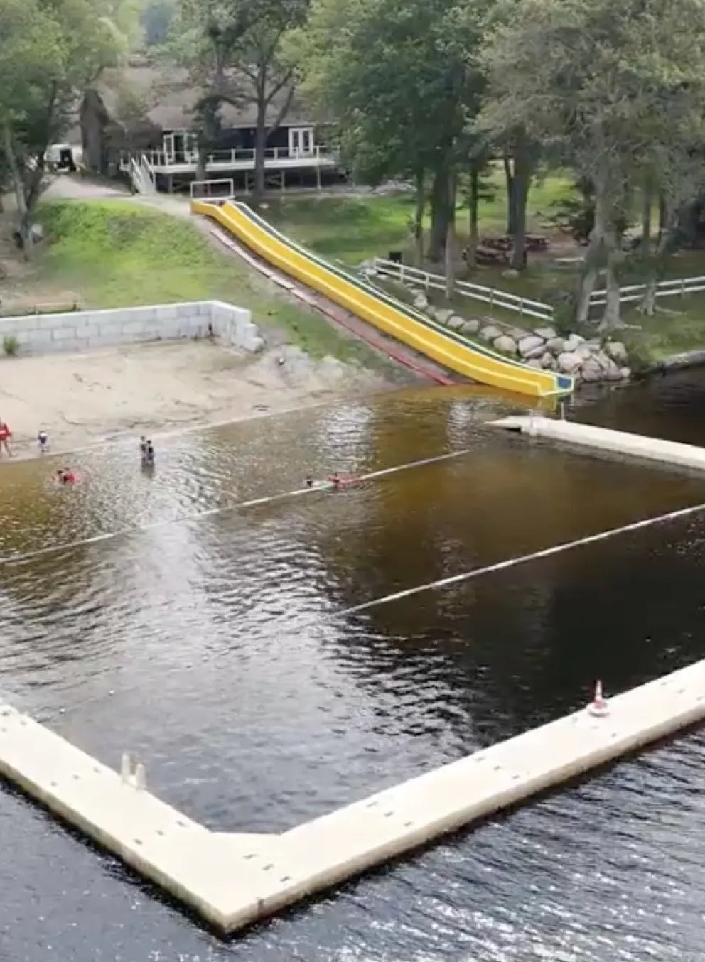 Waterfront with docks, sand, and a waterslide