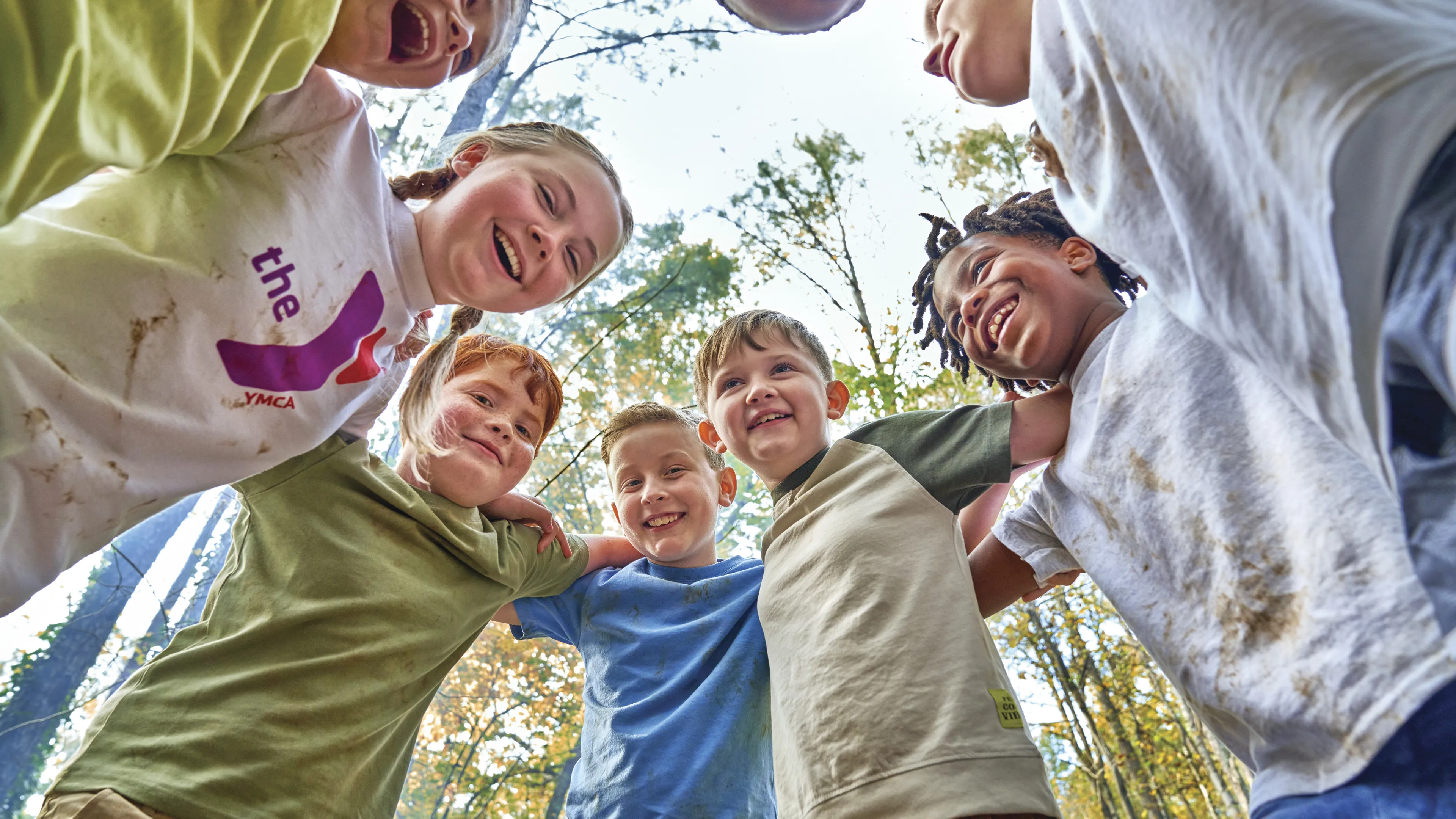 Kids laughing in a huddle outside