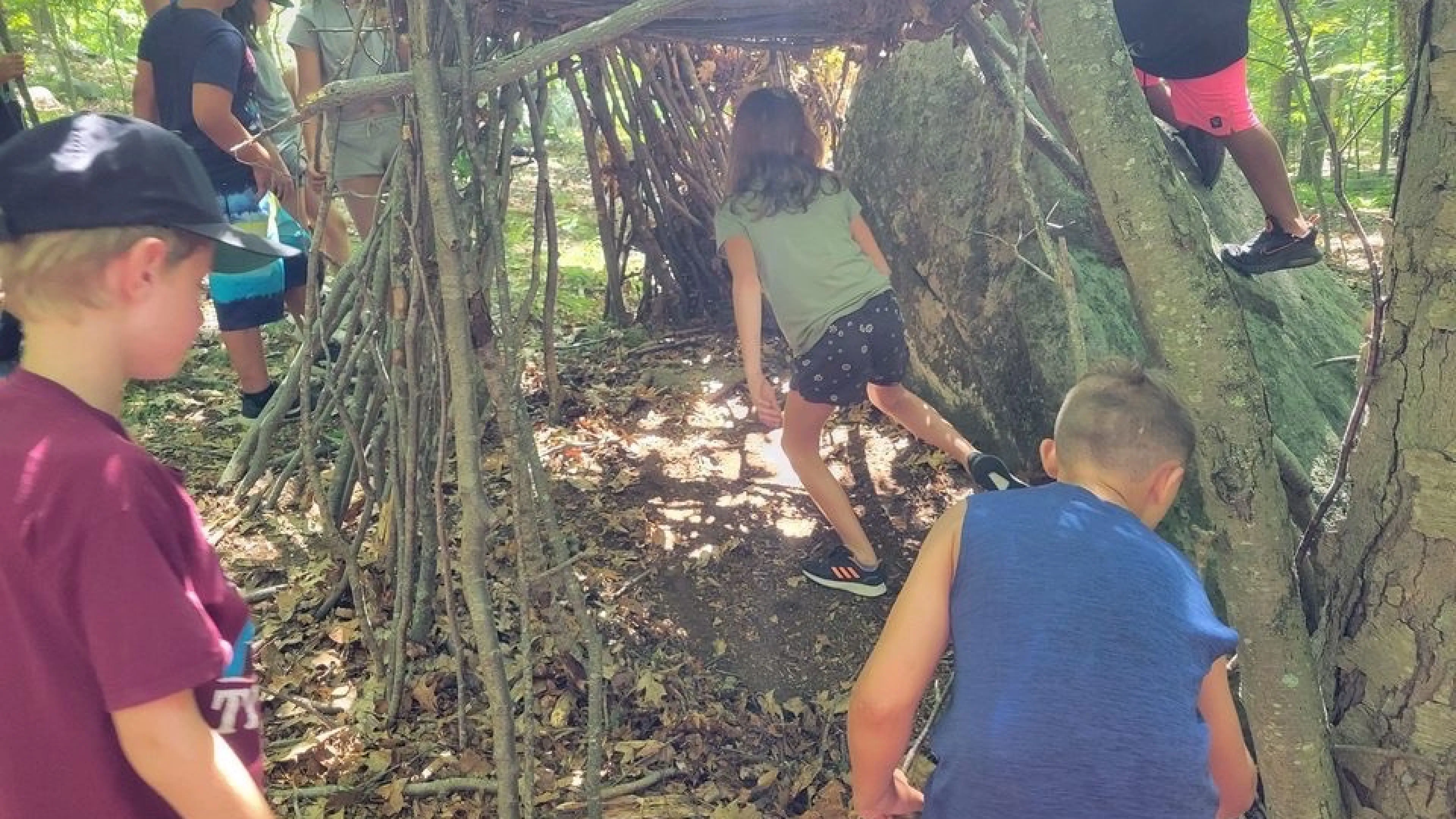 Kids building a fort out of nature