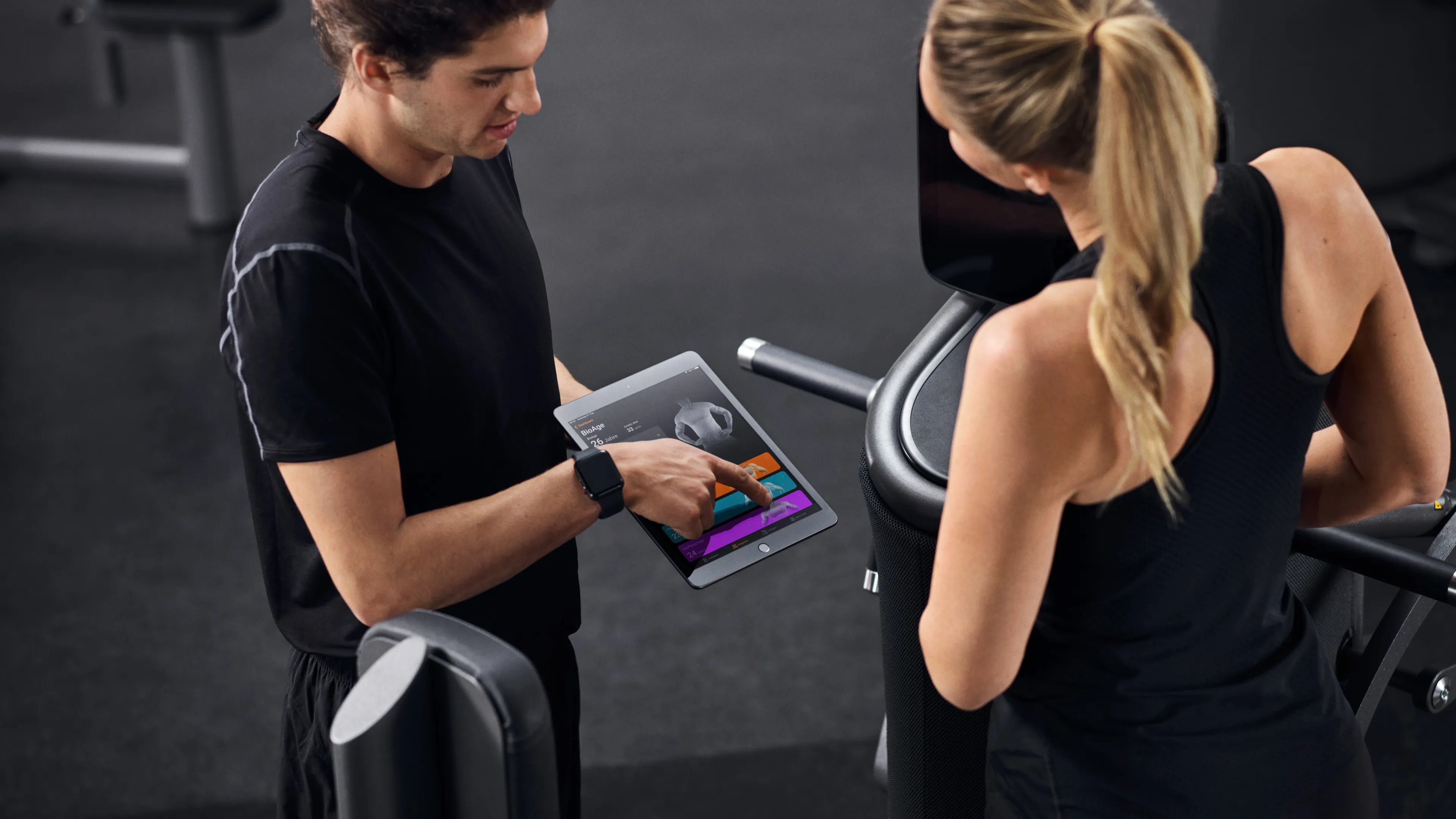 Trainer showing client a tablet