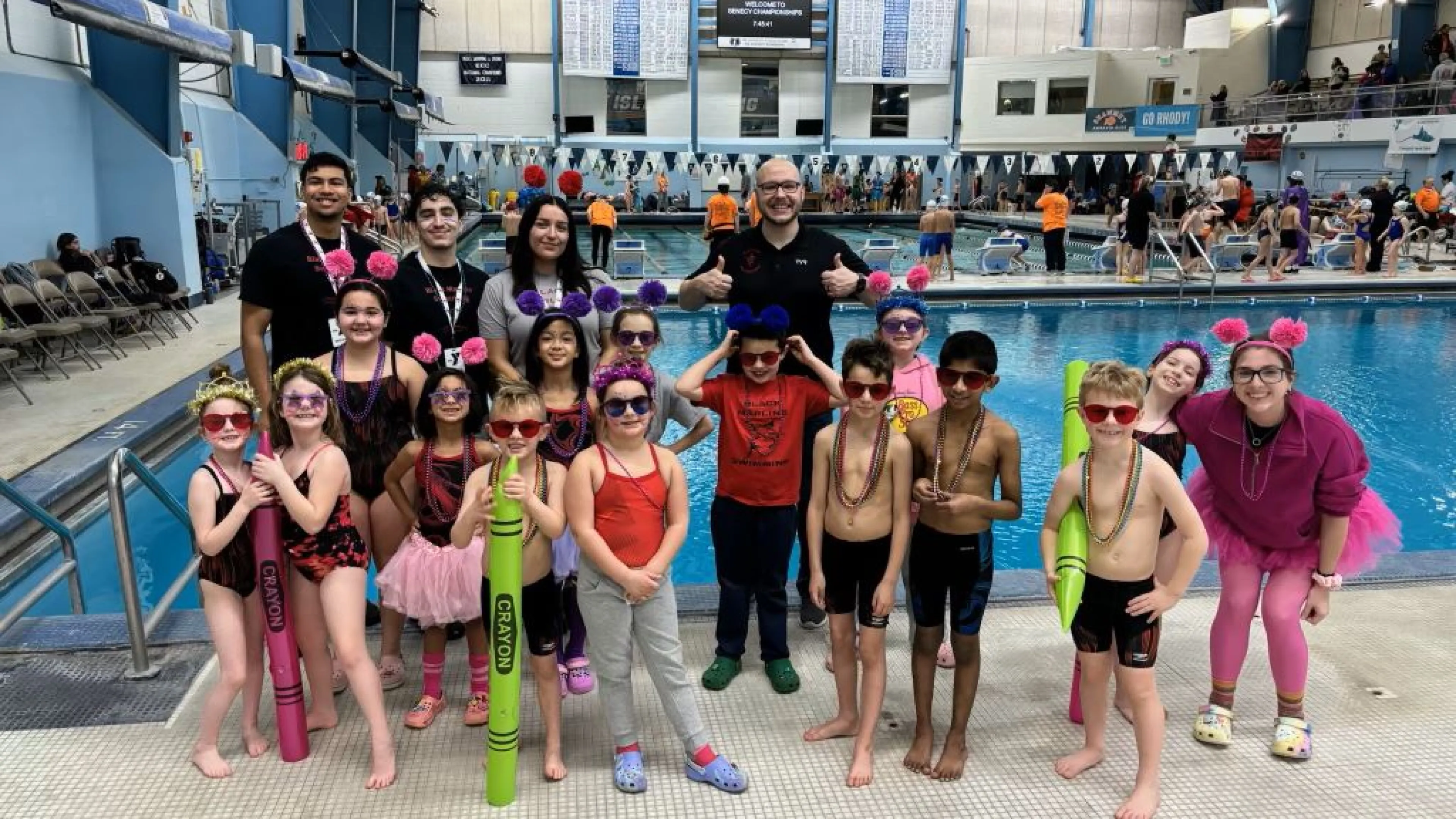 Swim Team posing with coaches at Swim Meet
