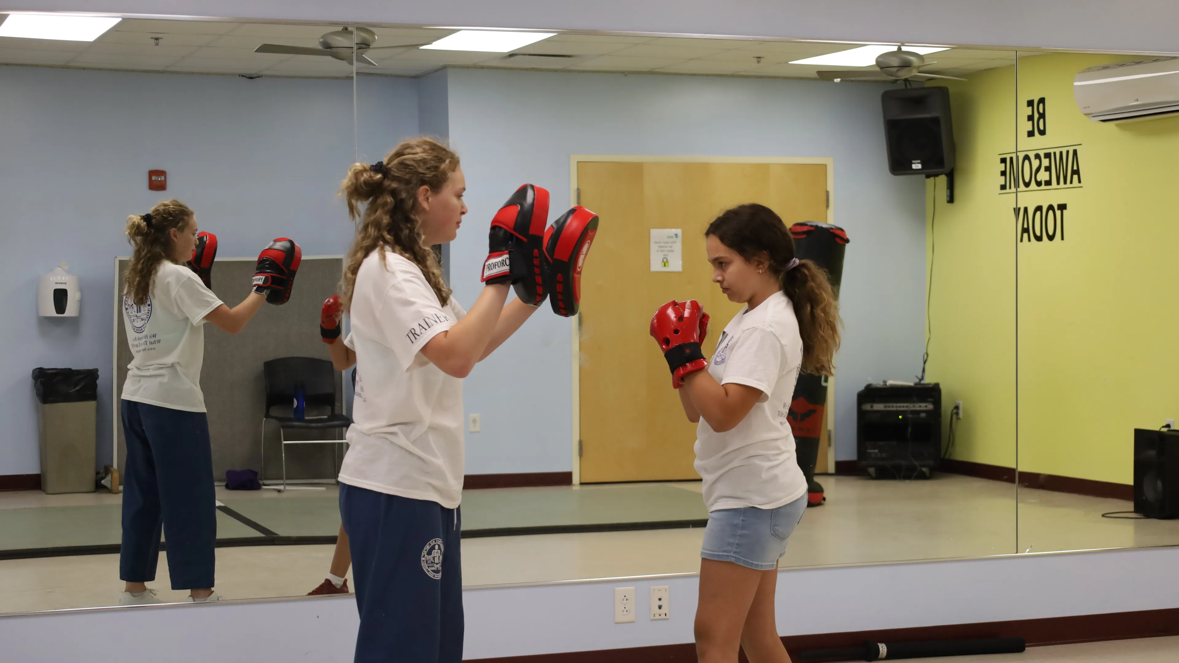 Female student working with female instructor on punches.