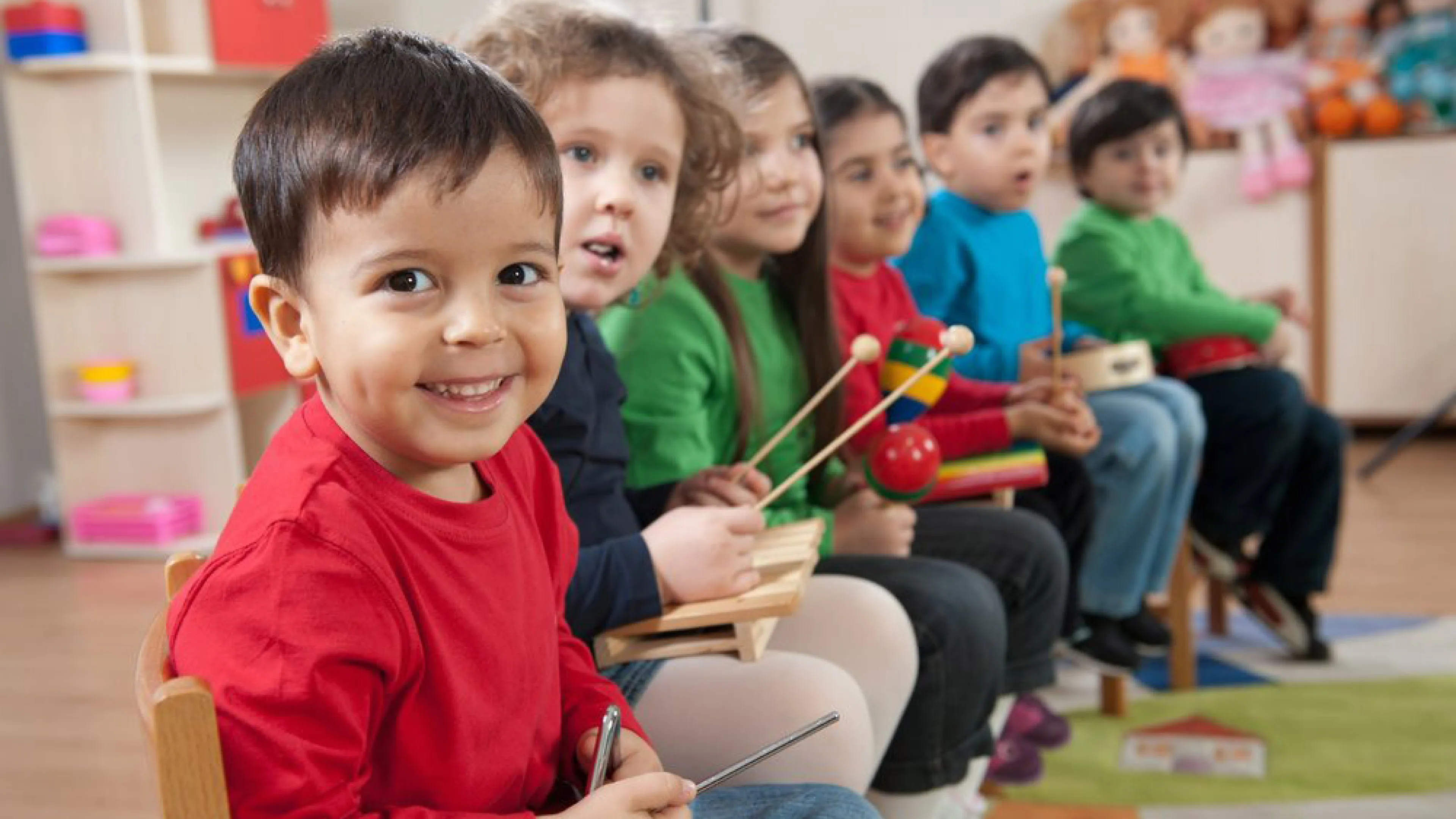 Young kids playing a variety of different musical instruments