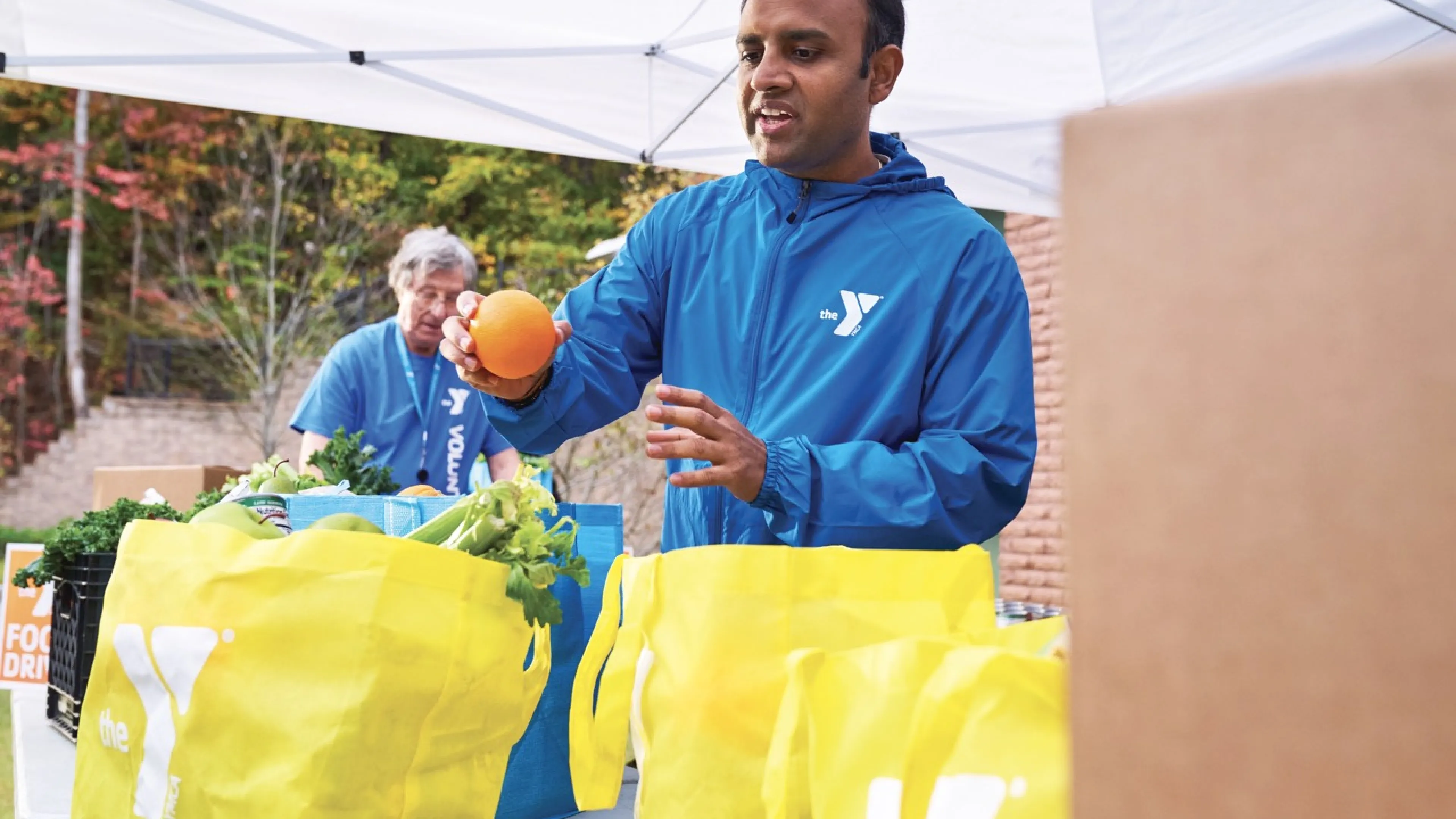 Male volunteer placing fruit in bags
