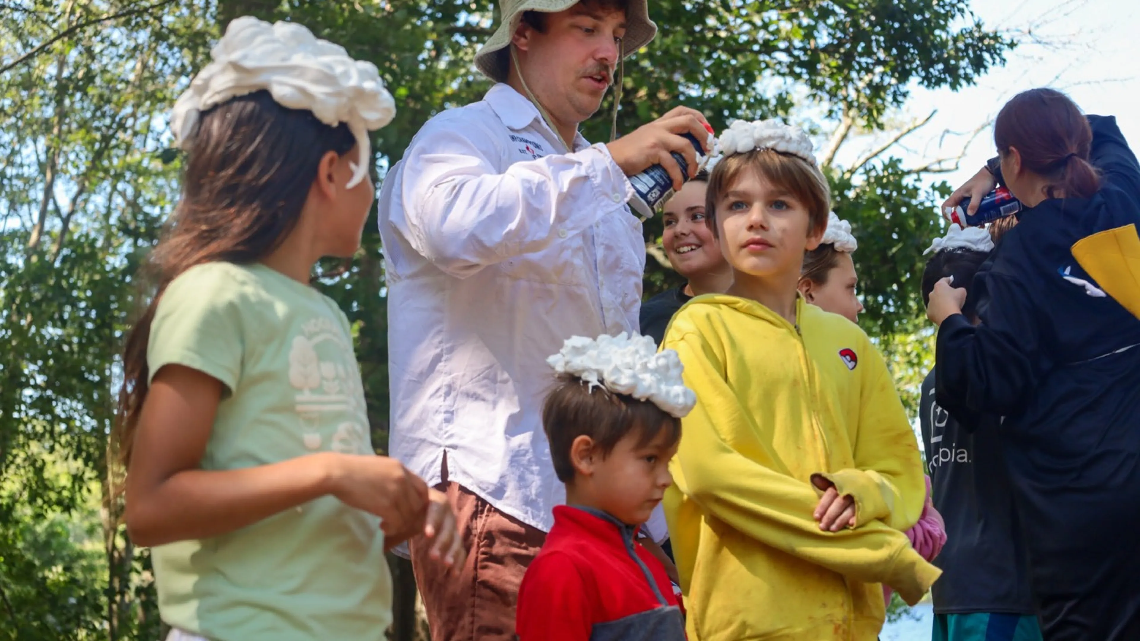 Line of campers having shaving cream put on their hair by a counselor