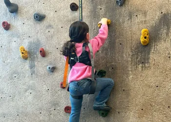Girl climbing rock wall