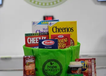 Green bag that says &quot;Hope Market&quot; with various non-perishable items in it.