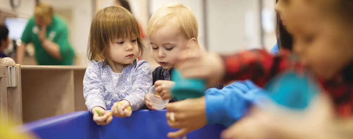 Toddlers playing in toy bin