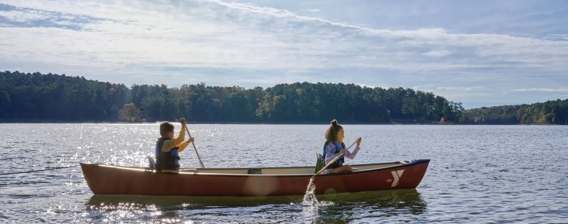 Kids rowing a canoe on a lake