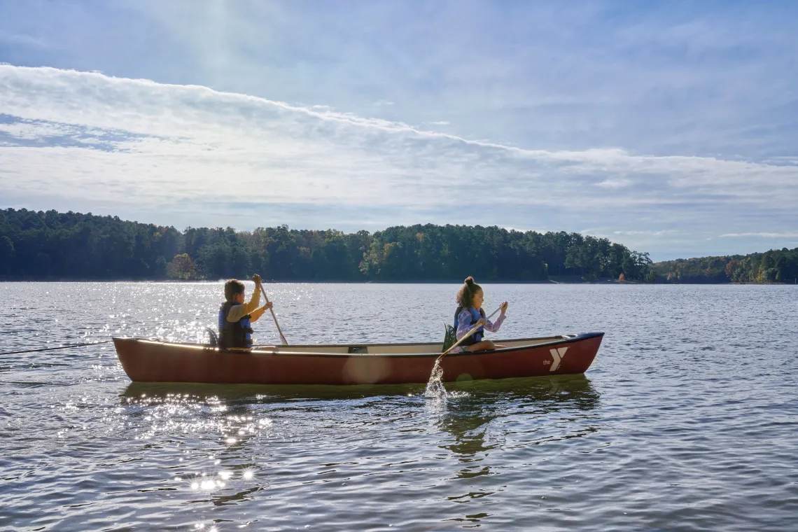 Kids rowing a canoe on a lake