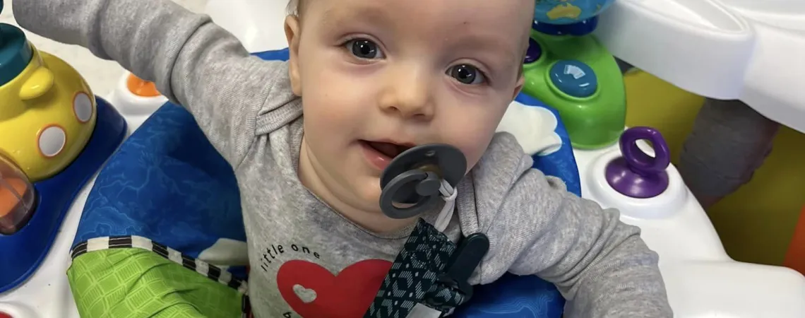 Infant boy playing in bouncer