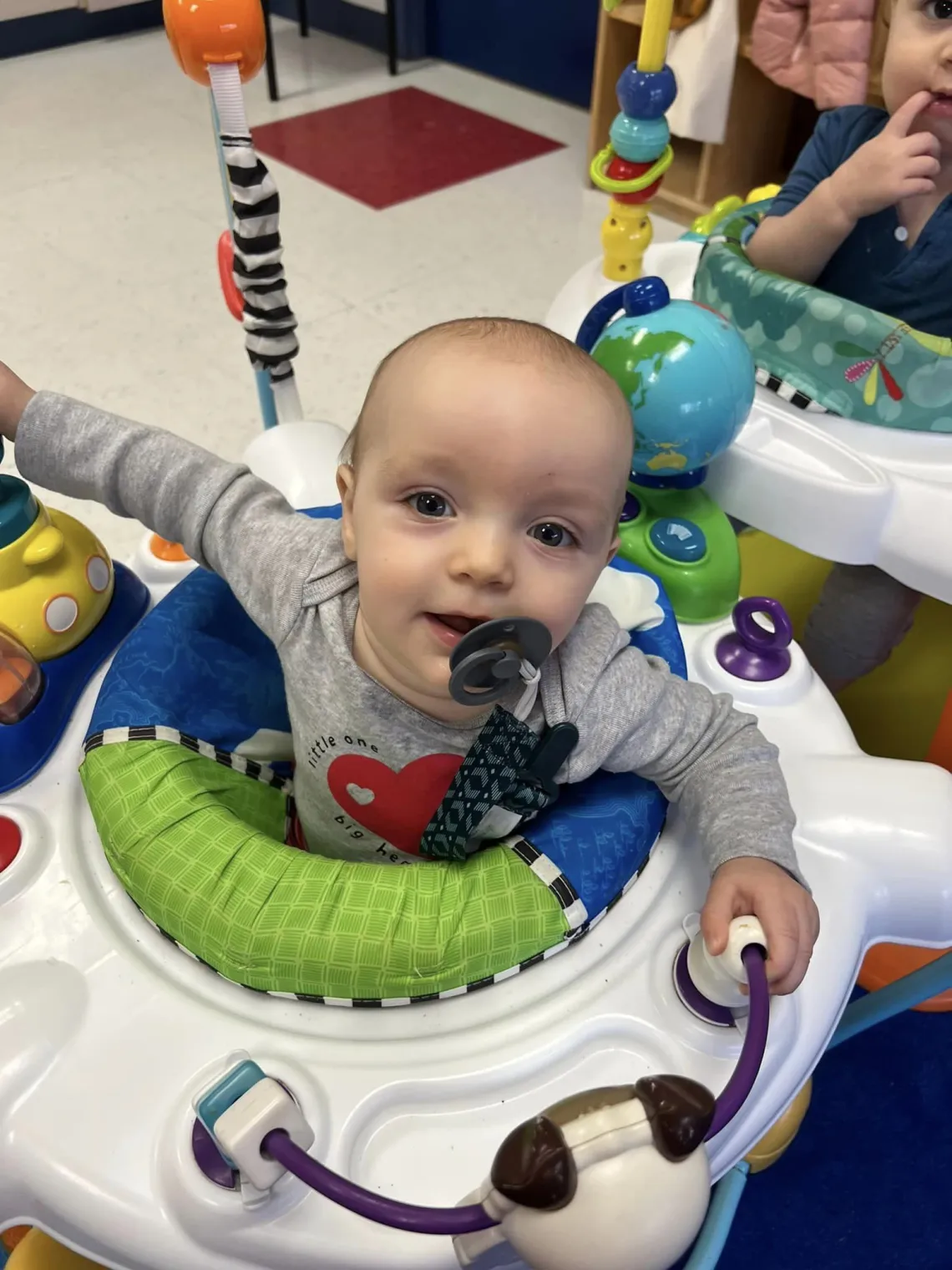 Infant boy playing in bouncer