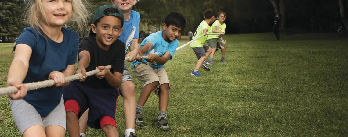 Girls and boys playing tug of war