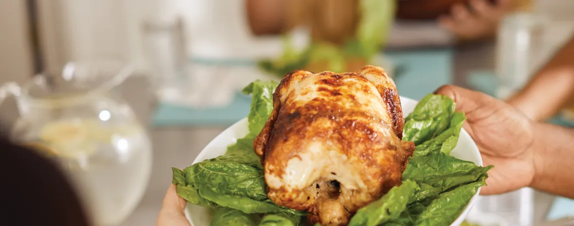 Plate with lettuce and chicken on it being served to a table