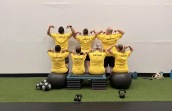 LiveStrong participants pointing to the word "survivor" on the back of their shirts.