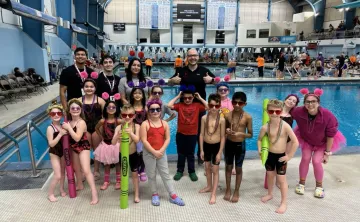 Swim Team posing with coaches at Swim Meet