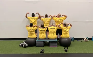 LiveStrong participants pointing to the word "survivor" on the back of their shirts.